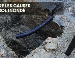 Trou dans le sol d'un jardin causé par des travaux de drainage après de fortes pluies.