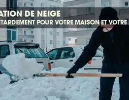 Person shoveling a large amount of accumulated snow near a parked car.